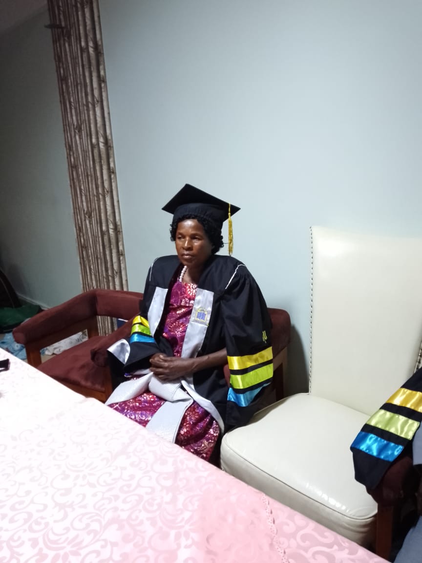 A graduate in academic dress seated after the ceremony