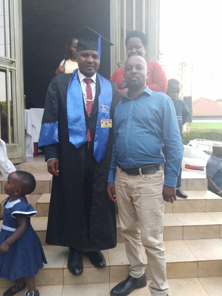 A graduate posing with a guest after completing his studies